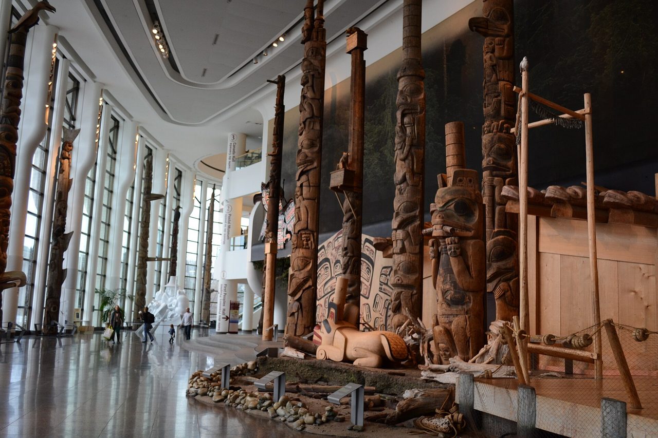 Towering totem poles lined up inside the Grand Hall of the Canadian Museum of History