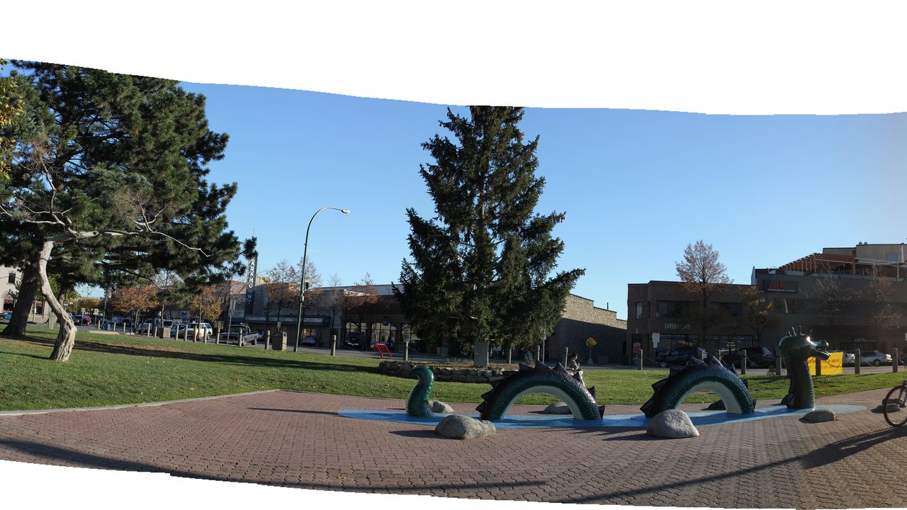 The Ogopogo lake-monster statue in a Kelowna waterfront park with the city and lake beyond