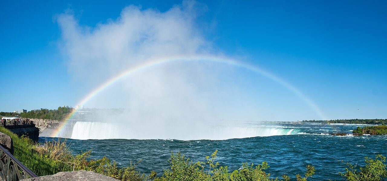 Rainbow arcing over the Horseshoe Falls at Niagara Falls, Ontario, with mist rising from the gorge