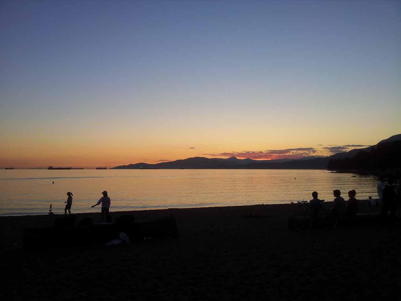 Final light of day over the sand and water at English Bay Beach