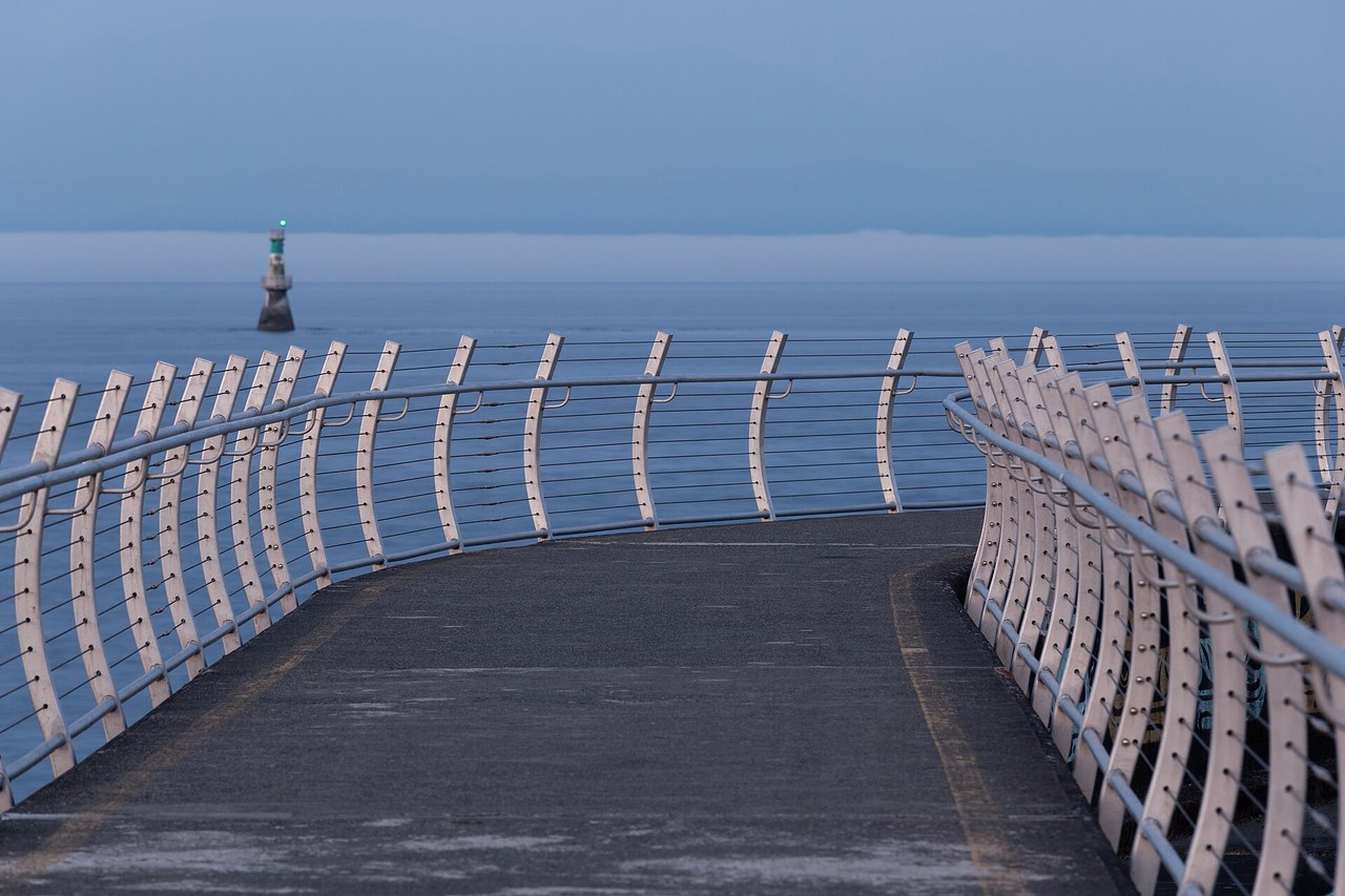 The Ogden Point breakwater walkway curving along the water at the end of Victoria's Dallas Road waterfront