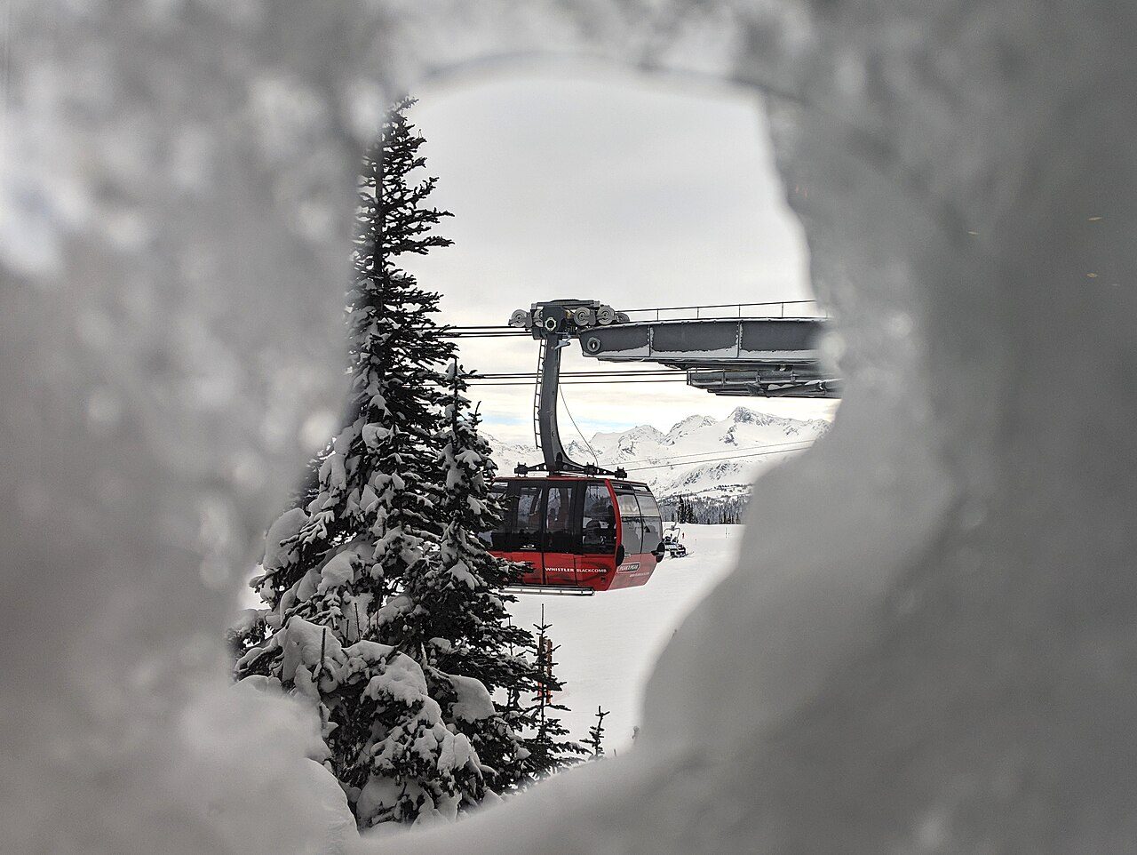 A PEAK 2 PEAK gondola cabin gliding past the Roundhouse Lodge window on Whistler Mountain