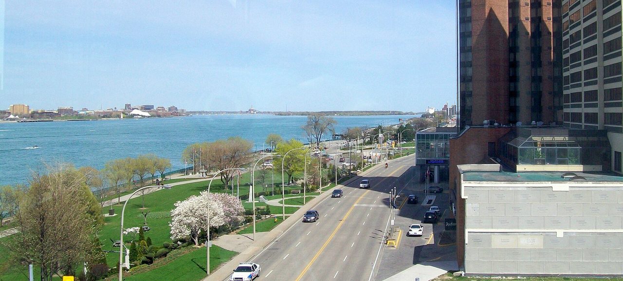 Dieppe Gardens and the riverfront trail along Riverside Drive, with the Detroit River and Belle Isle beyond