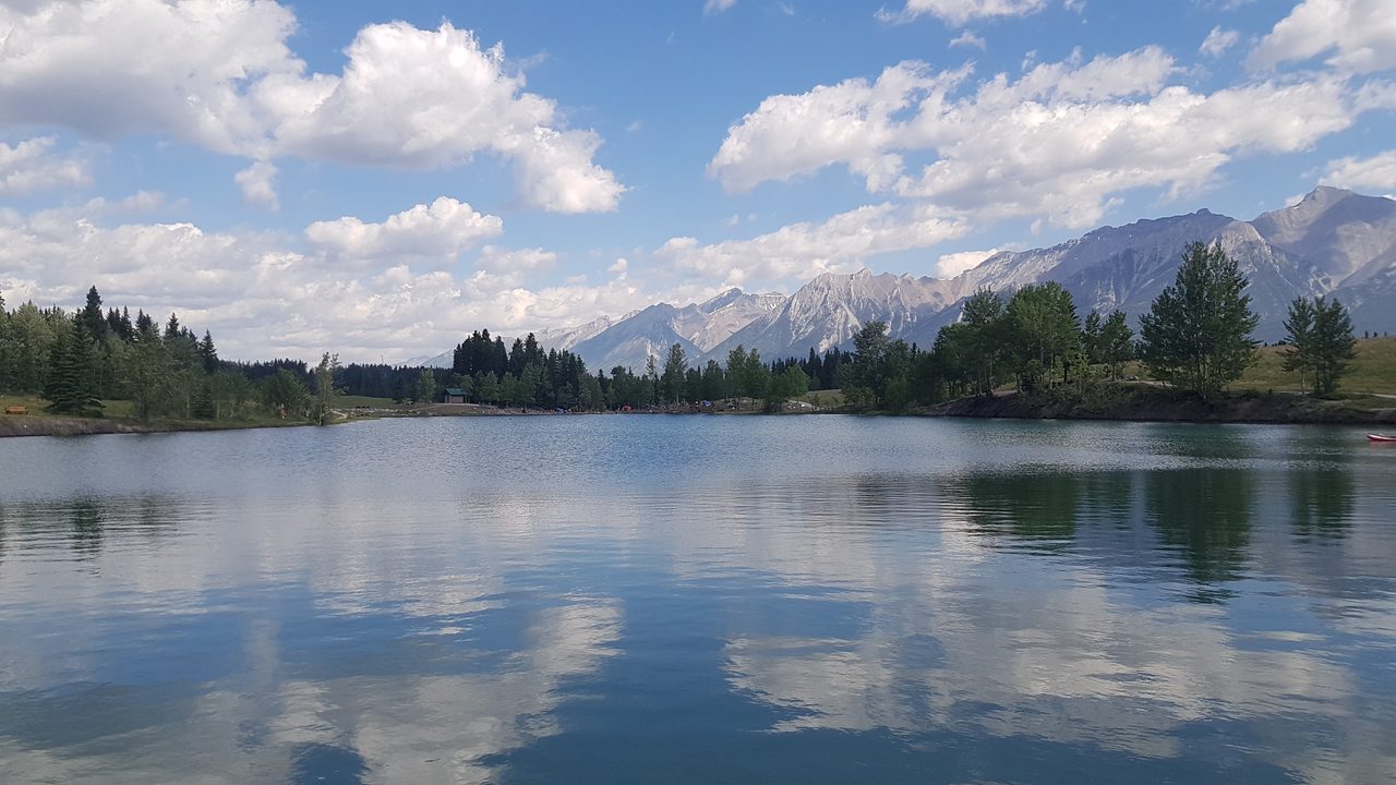 Calm waters of Quarry Lake with mountains reflected in the distance