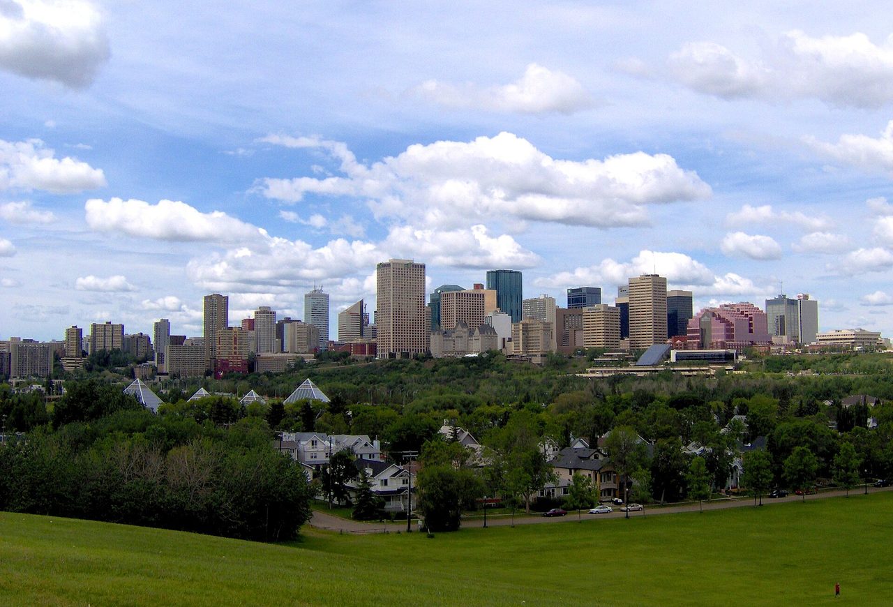 Edmonton downtown skyline rising above the green North Saskatchewan River Valley on a clear summer day