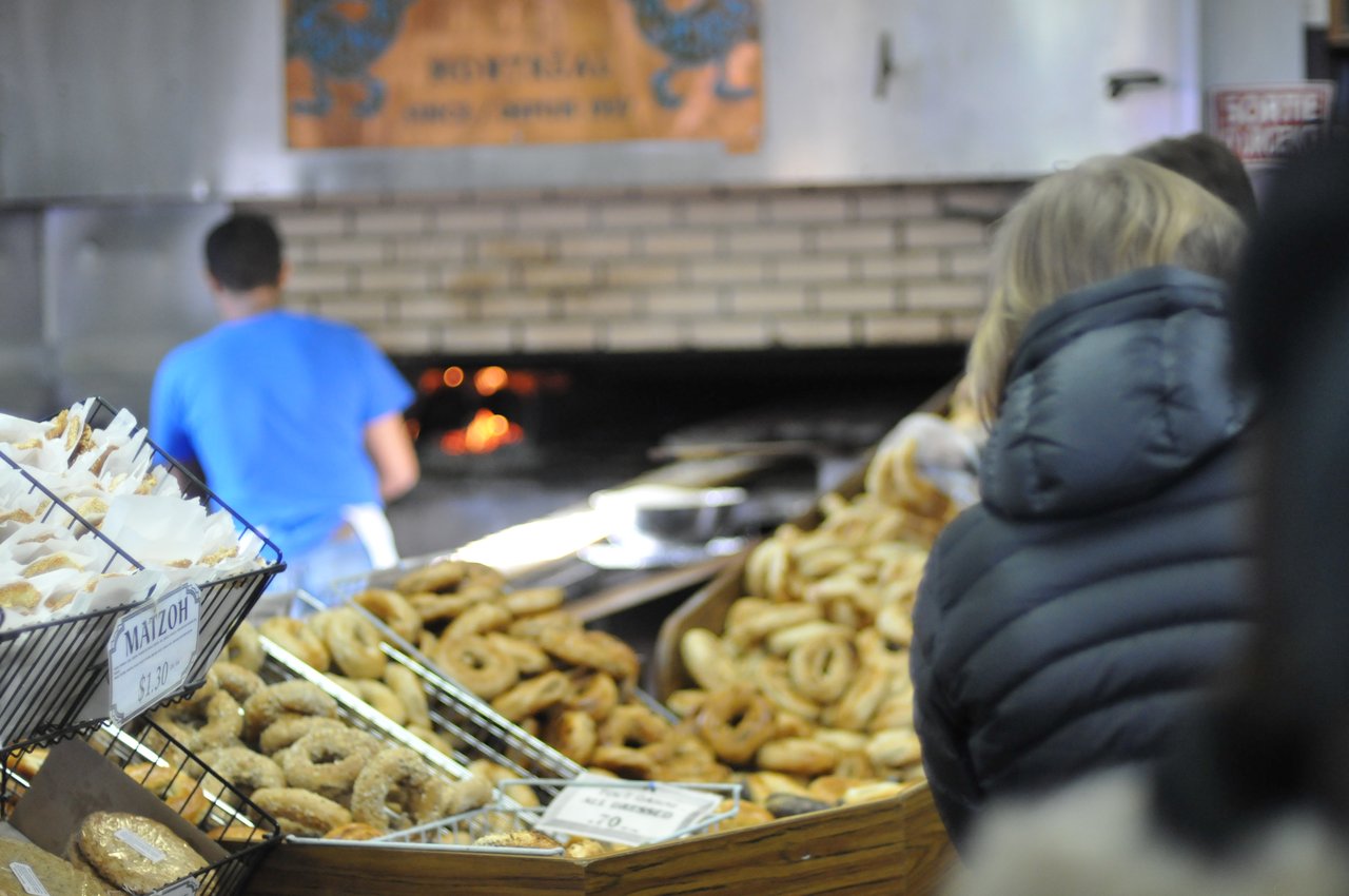 Fresh wood-fired Montreal bagels piled in a paper bag