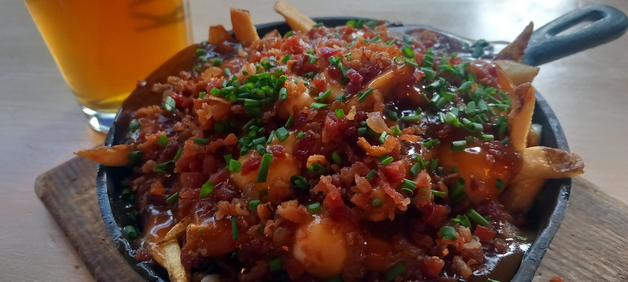 A classic Quebec poutine with cheese curds, gravy, and crispy bacon bits