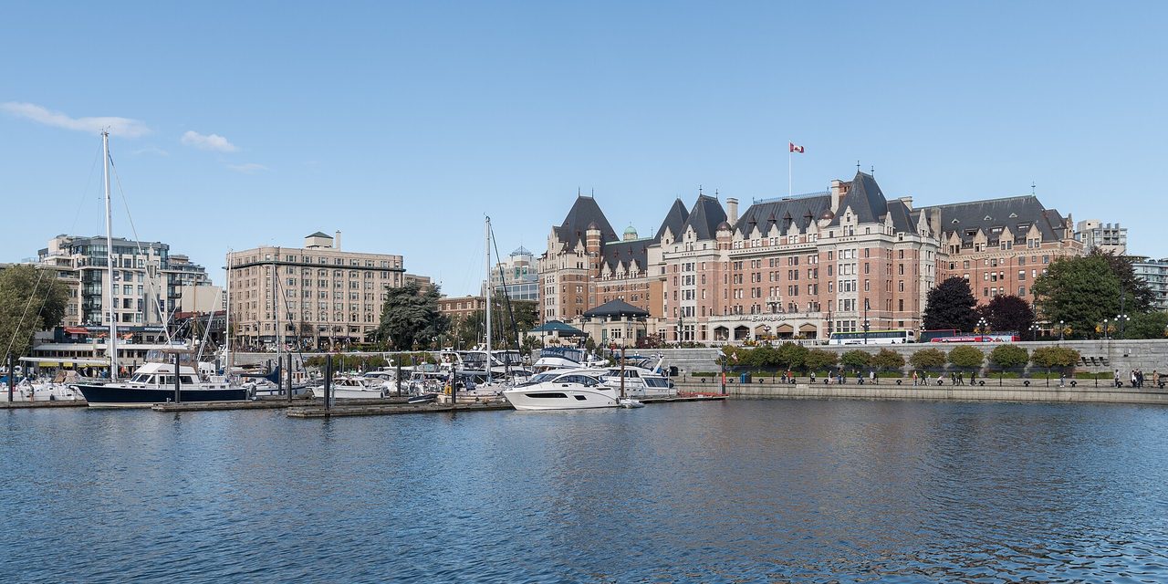 Victoria's Inner Harbour and the Fairmont Empress Hotel at dusk, with boats moored in front of the historic stone hotel