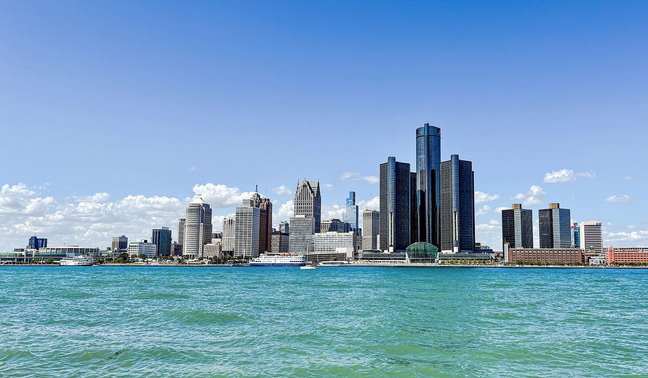 The Detroit skyline glowing across the Detroit River, photographed from the Windsor riverfront at dusk