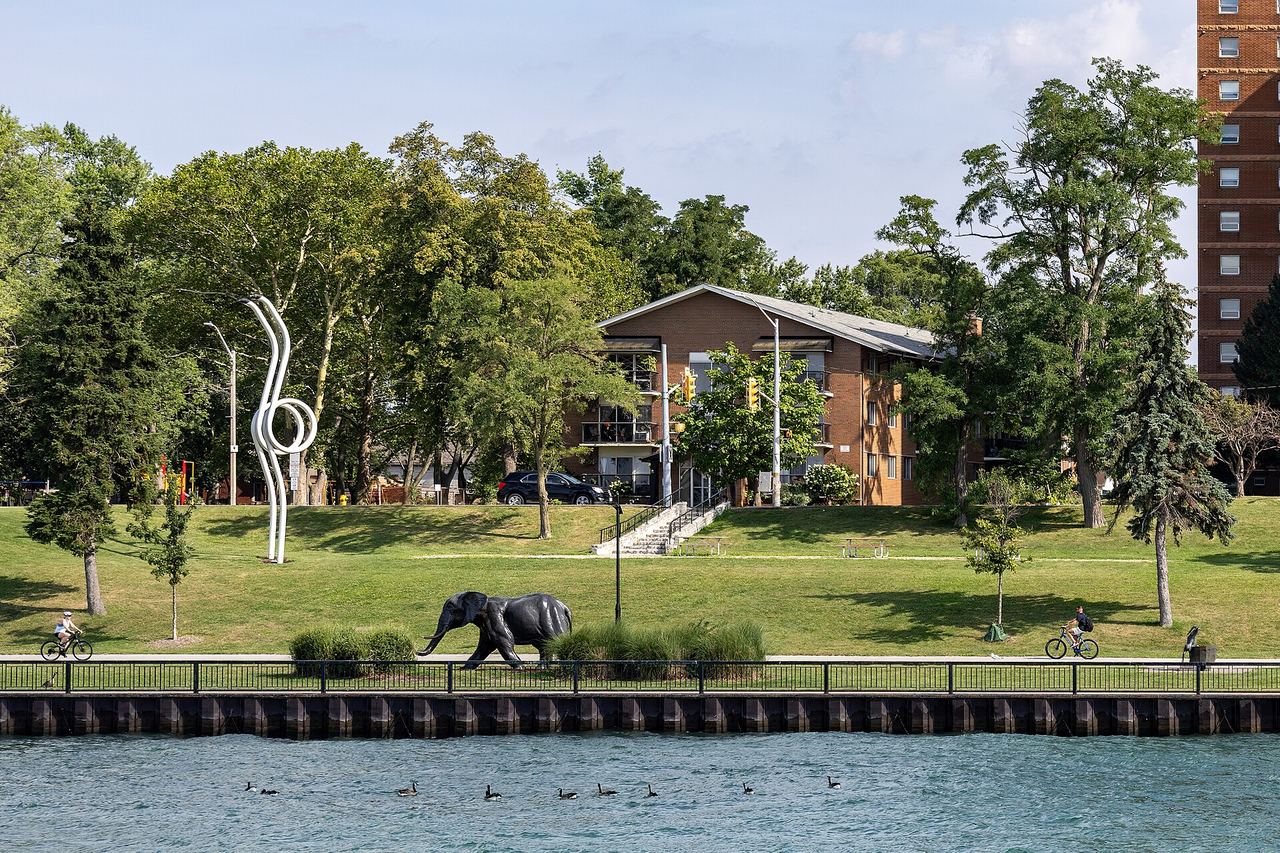 Sculptures along the Odette Sculpture Park riverfront in Windsor, Ontario, with the Detroit River in the background