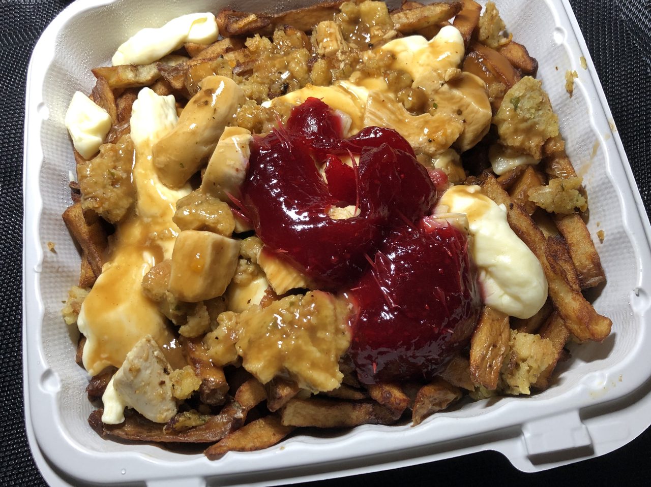 A loaded poutine, the classic Quebec comfort dish, served in a basket