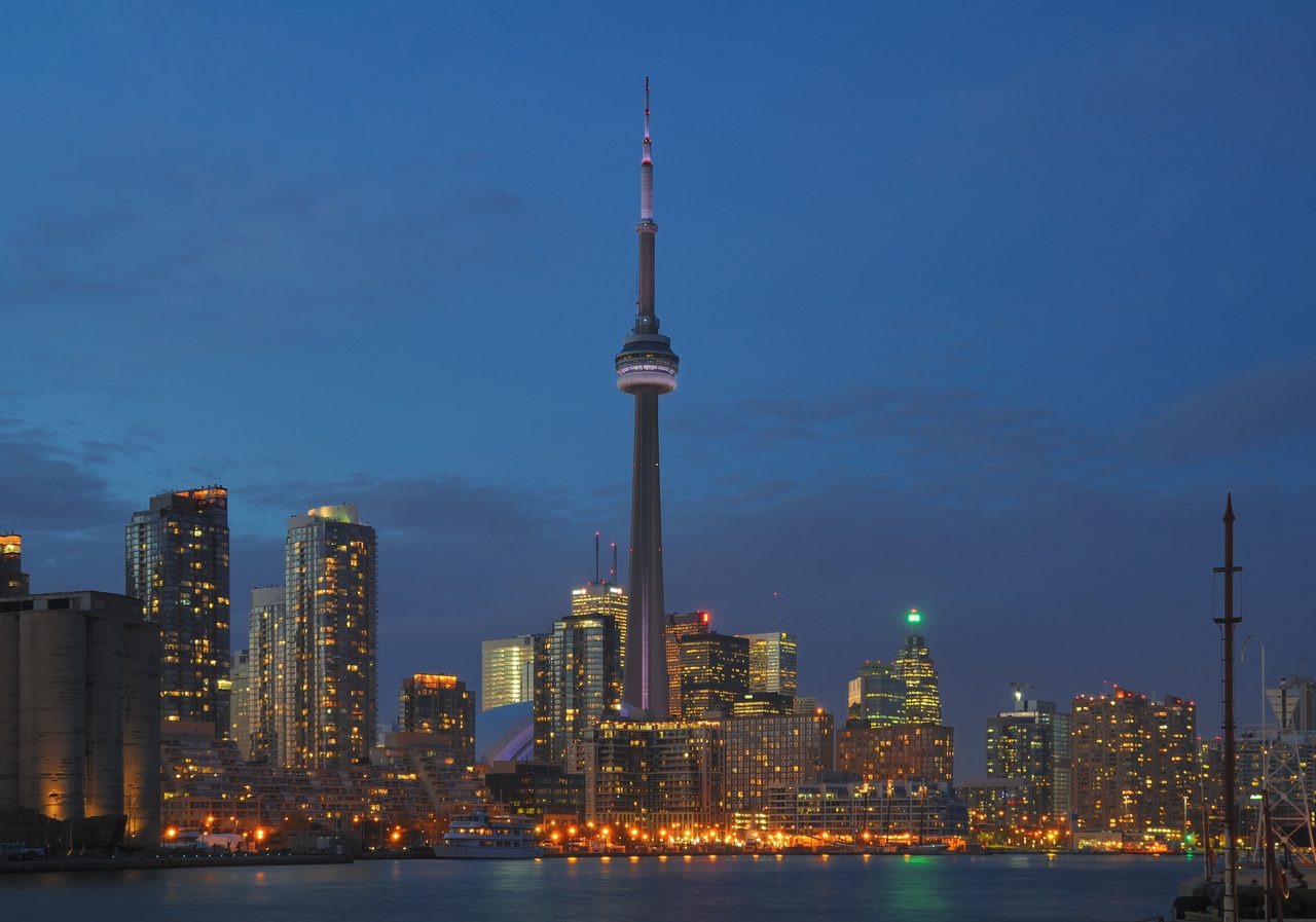 Toronto skyline at night with the illuminated CN Tower rising above the downtown towers