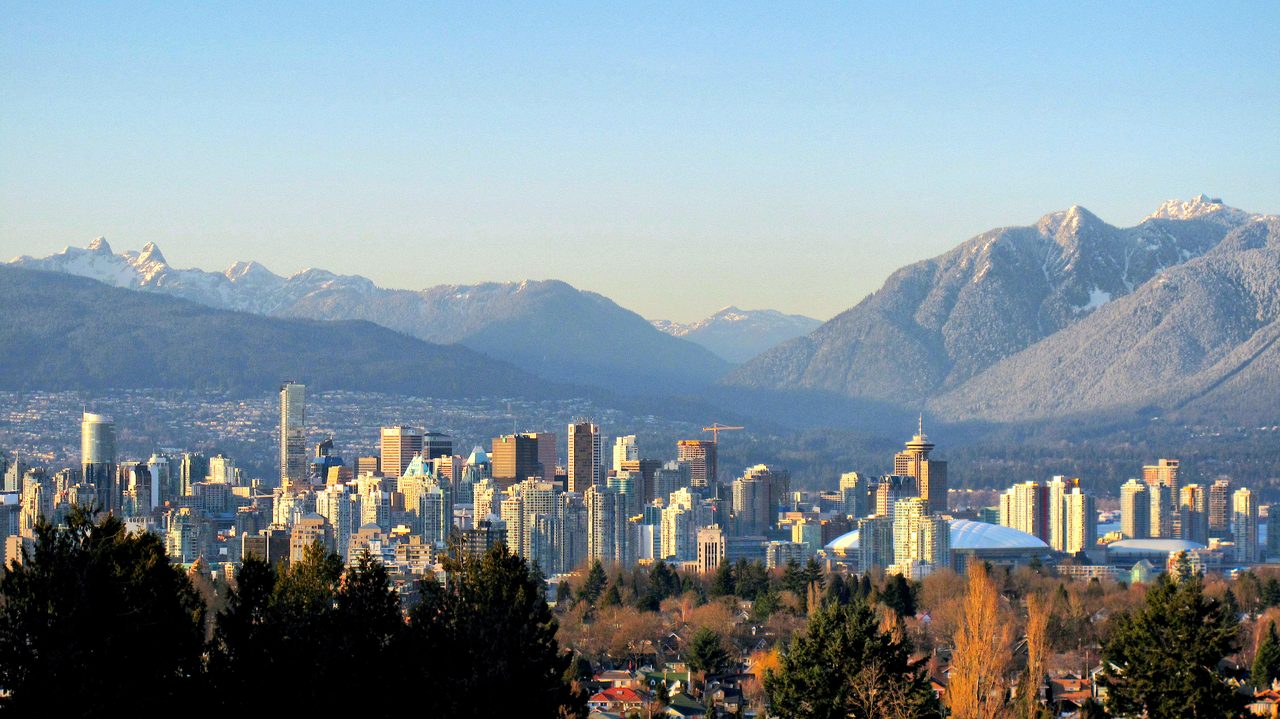 Vancouver skyline backed by snow-dusted North Shore Mountains across the water