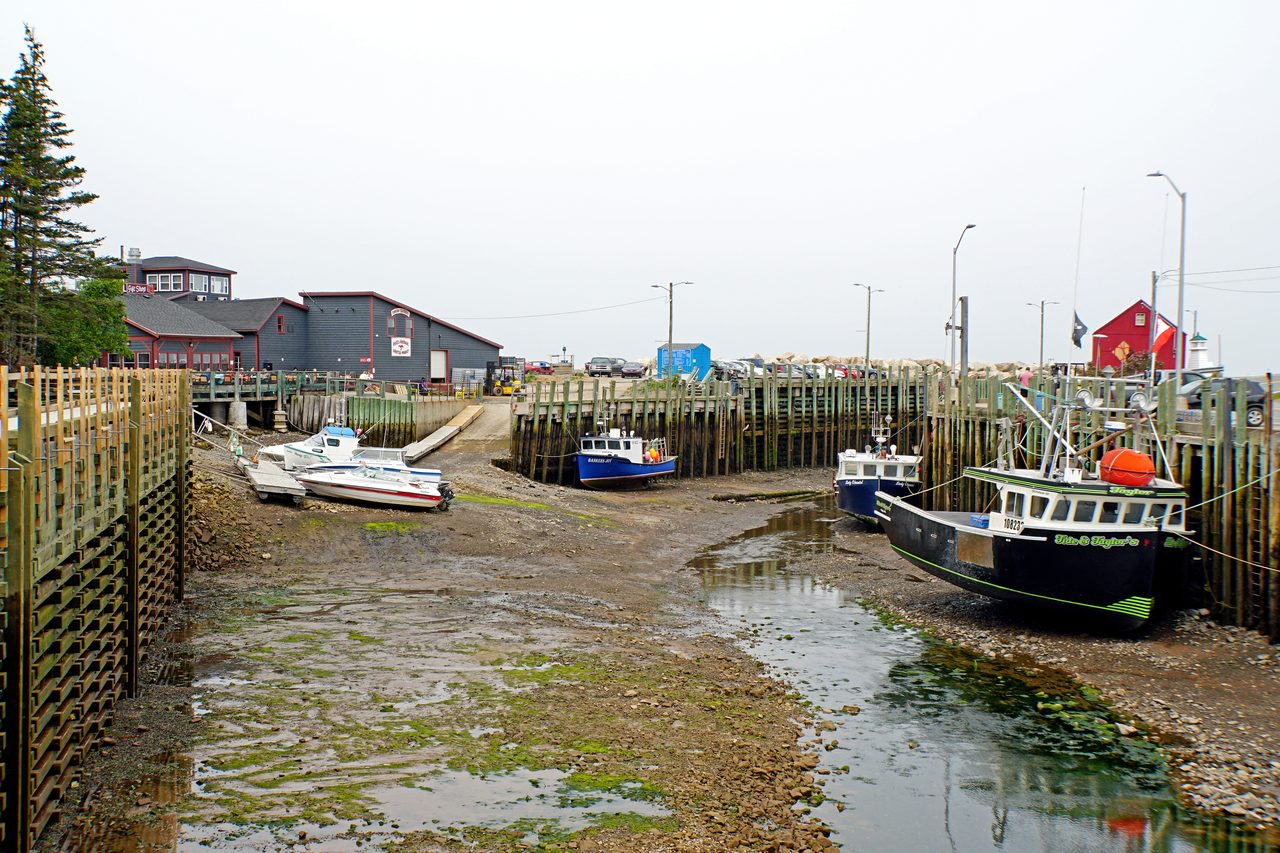 Fishing boats resting on the harbour floor at low tide in Hall's Harbour on the Bay of Fundy