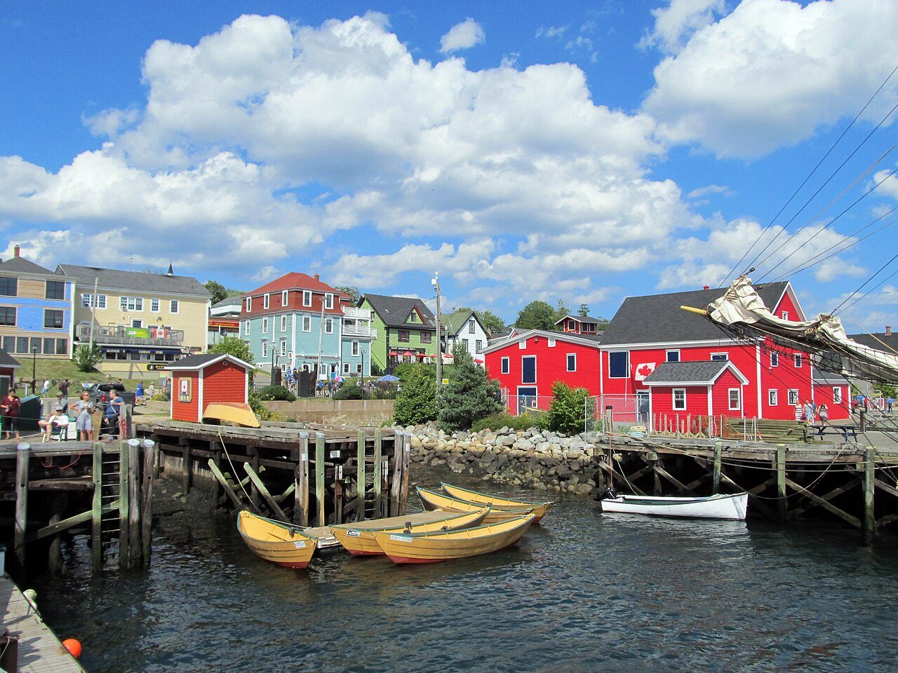 Red waterfront buildings and yellow wooden dories moored in Lunenburg harbour