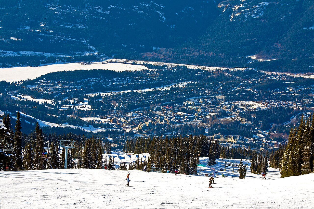 Whistler Village with gondolas and mountain peaks rising behind the pedestrian village