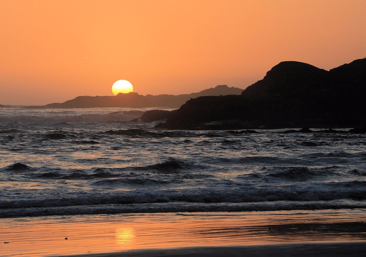 Sunset over the Pacific Ocean at Cox Bay beach in Tofino, British Columbia