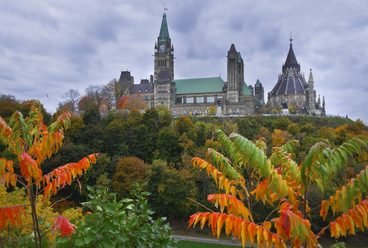 Parliament Hill's Centre Block and Peace Tower reflected in the Ottawa River at sunset