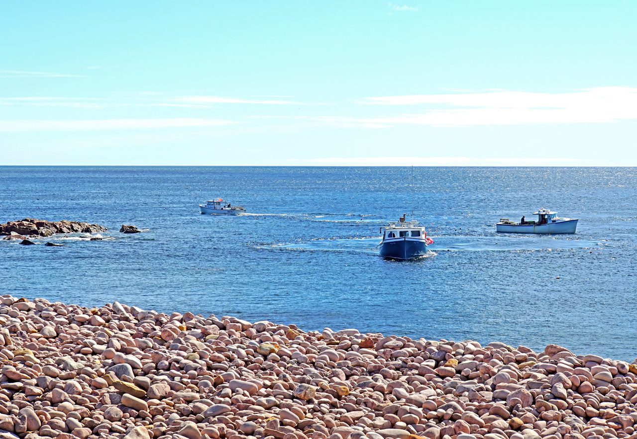 A lobster fishing boat and stacked lobster traps in Ingonish harbour on Cape Breton Island