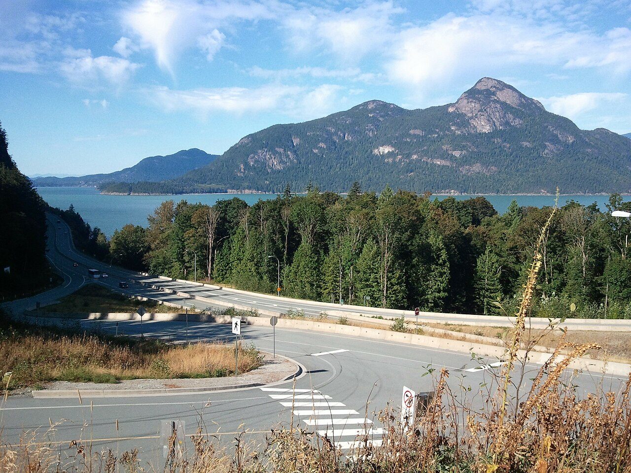 The Sea to Sky Highway winding along the shore of Howe Sound, with forested mountains rising behind