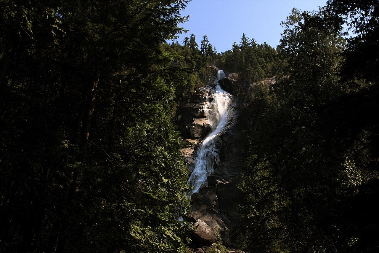 Shannon Falls dropping down a sheer cliff face through forest near Squamish, BC