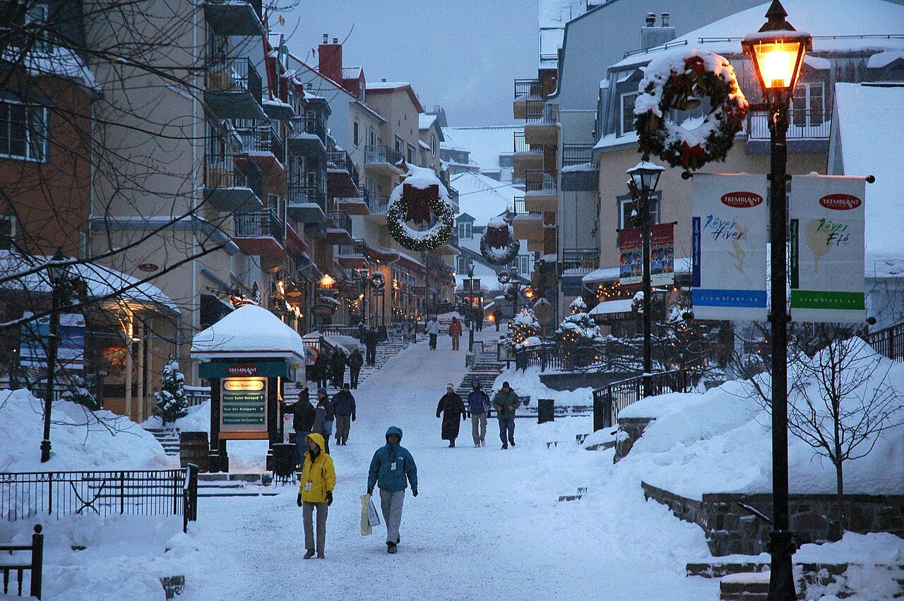 Snow-covered pedestrian village of Mont-Tremblant, Quebec, glowing at dusk
