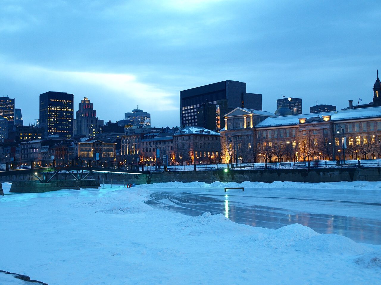 Outdoor skating rink at the Old Port of Montreal with skaters gliding on the ice