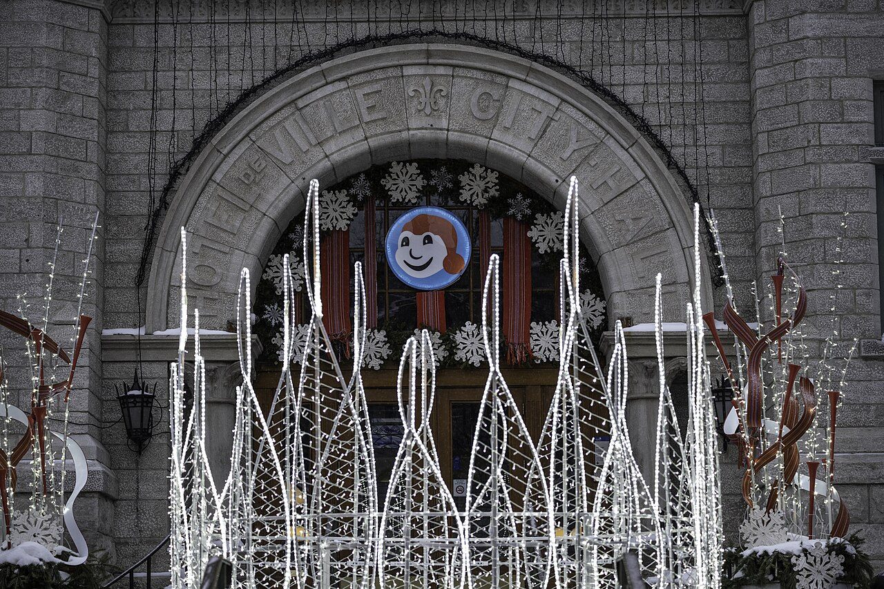 Stone archway in Old Quebec decorated with light sculptures and a Bonhomme Carnaval medallion for the Winter Carnival