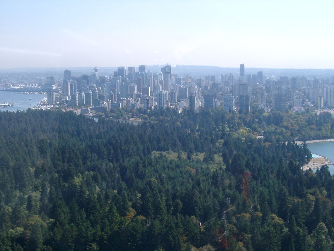 Aerial view of Vancouver with Stanley Park in the foreground and downtown towers beyond