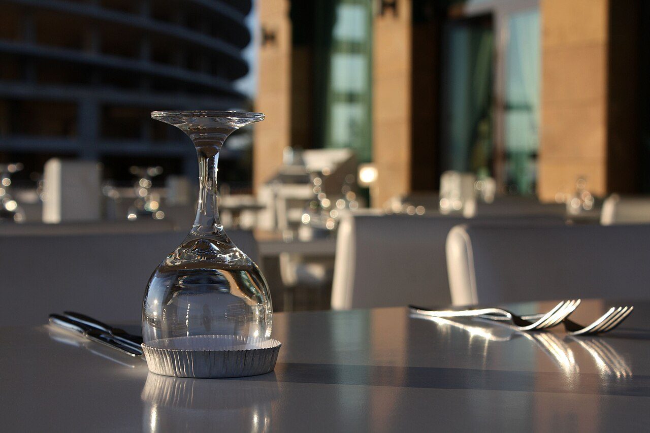 Wine glass and cutlery set on a restaurant table before dinner service