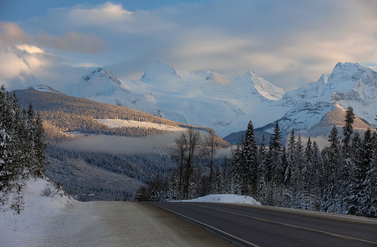 Snow-covered mountain peaks viewed from a winter highway in British Columbia