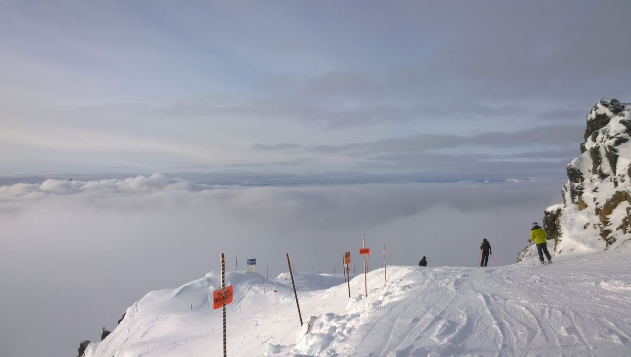 Skier descending a snowy slope above a sea of clouds at Whistler