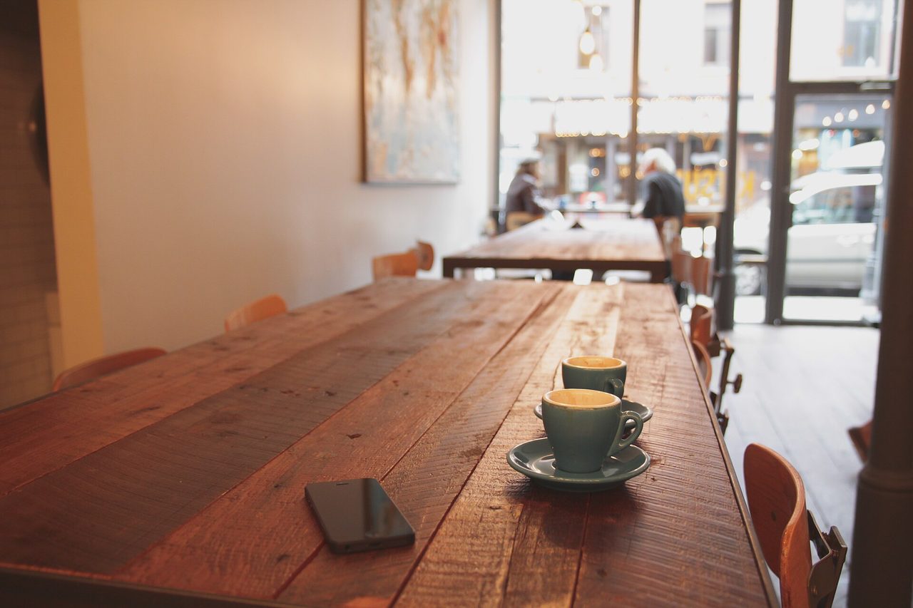 A warm cafe interior in Montreal with wooden tables, chairs, and a coffee bar