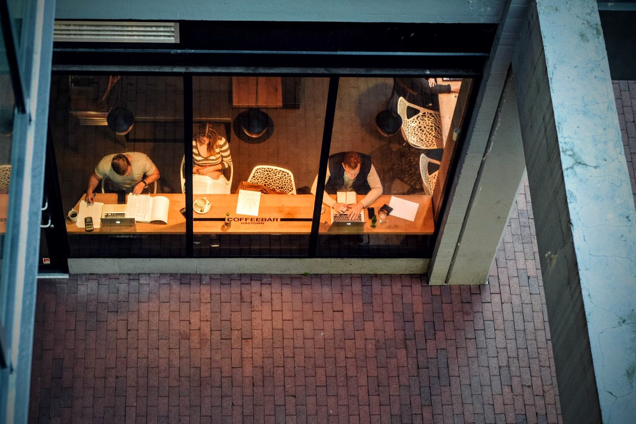 A busy café interior with people working at tables over coffee