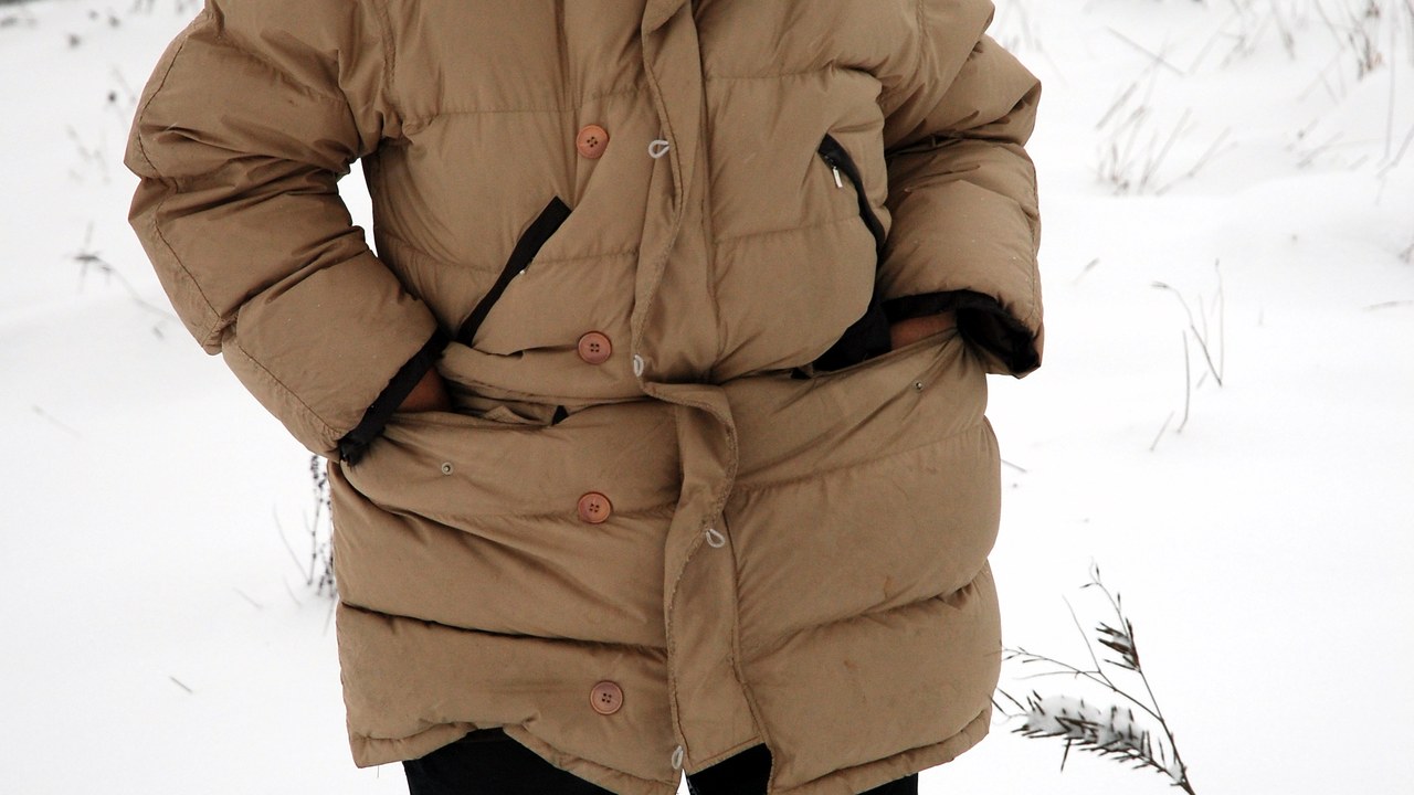 Traveler bundled in winter layers standing in fresh snow