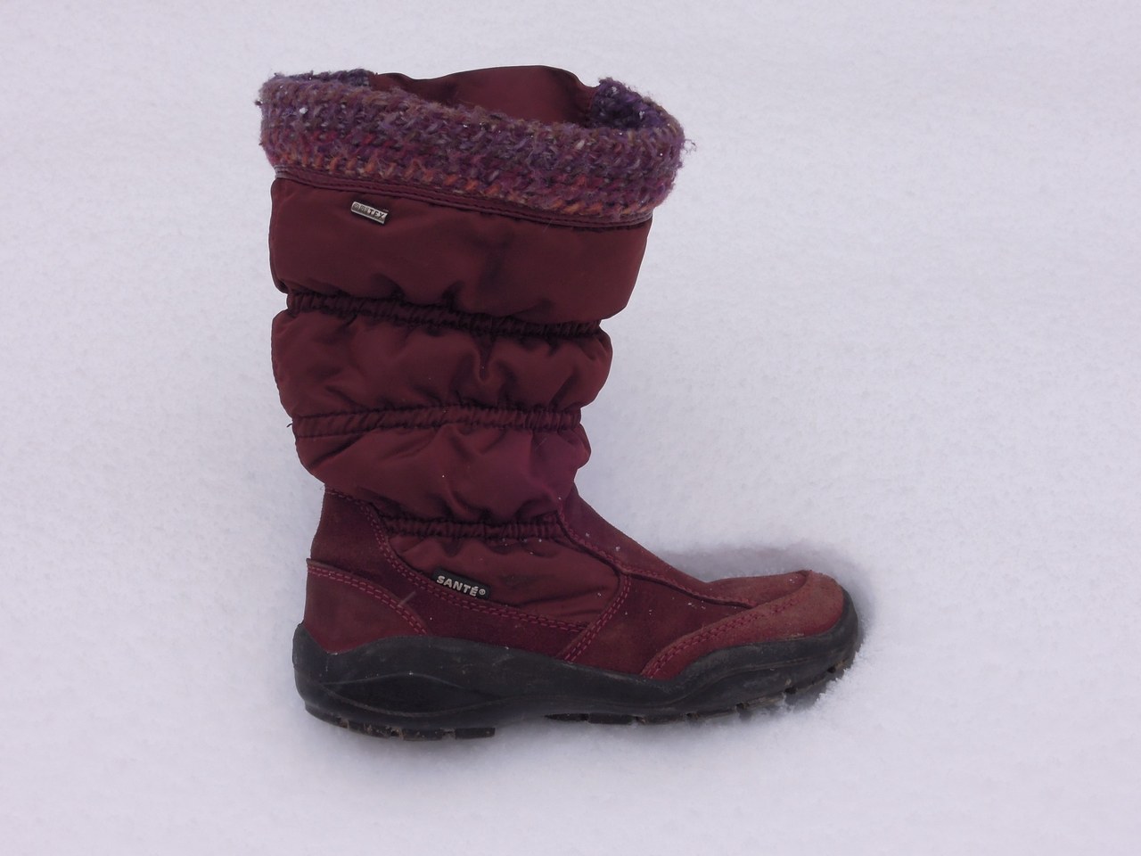 Insulated winter boot standing on fresh snow