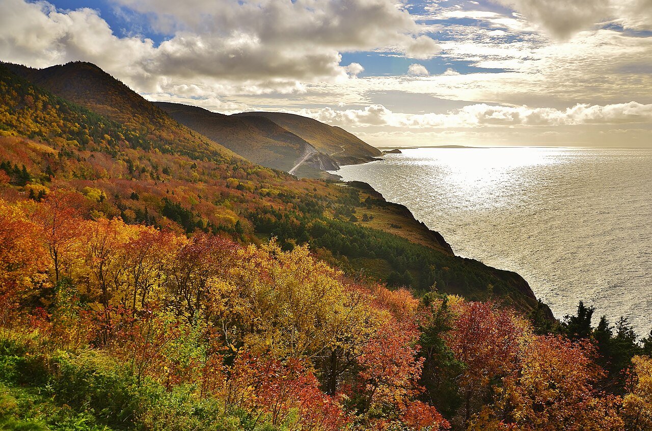 Cabot Trail cliffs wrapped in red and gold fall foliage above the Atlantic Ocean in Cape Breton