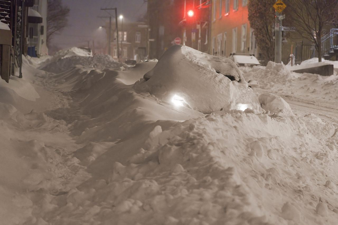 A snowplow clearing a street during a heavy snowstorm in Quebec City