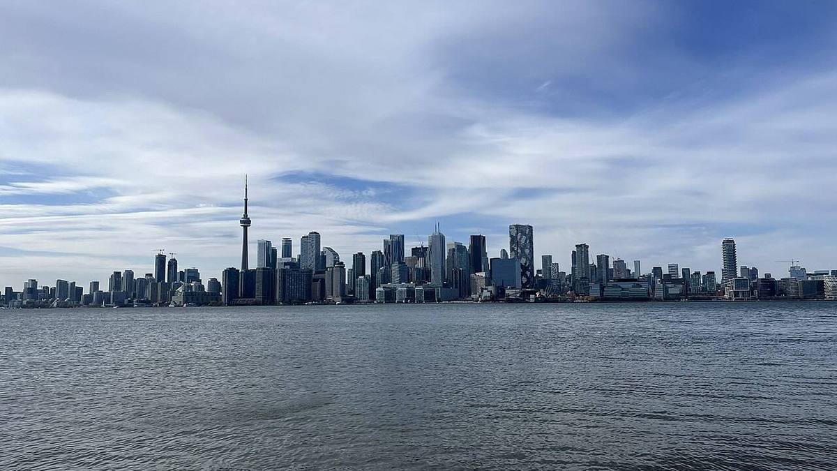 Downtown Toronto skyline with the CN Tower rising above the towers, seen across the harbour