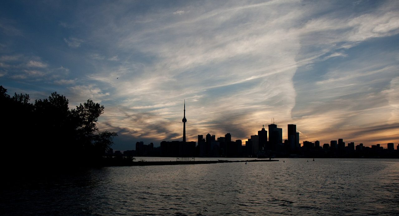 Toronto skyline at sunset with the CN Tower glowing above downtown