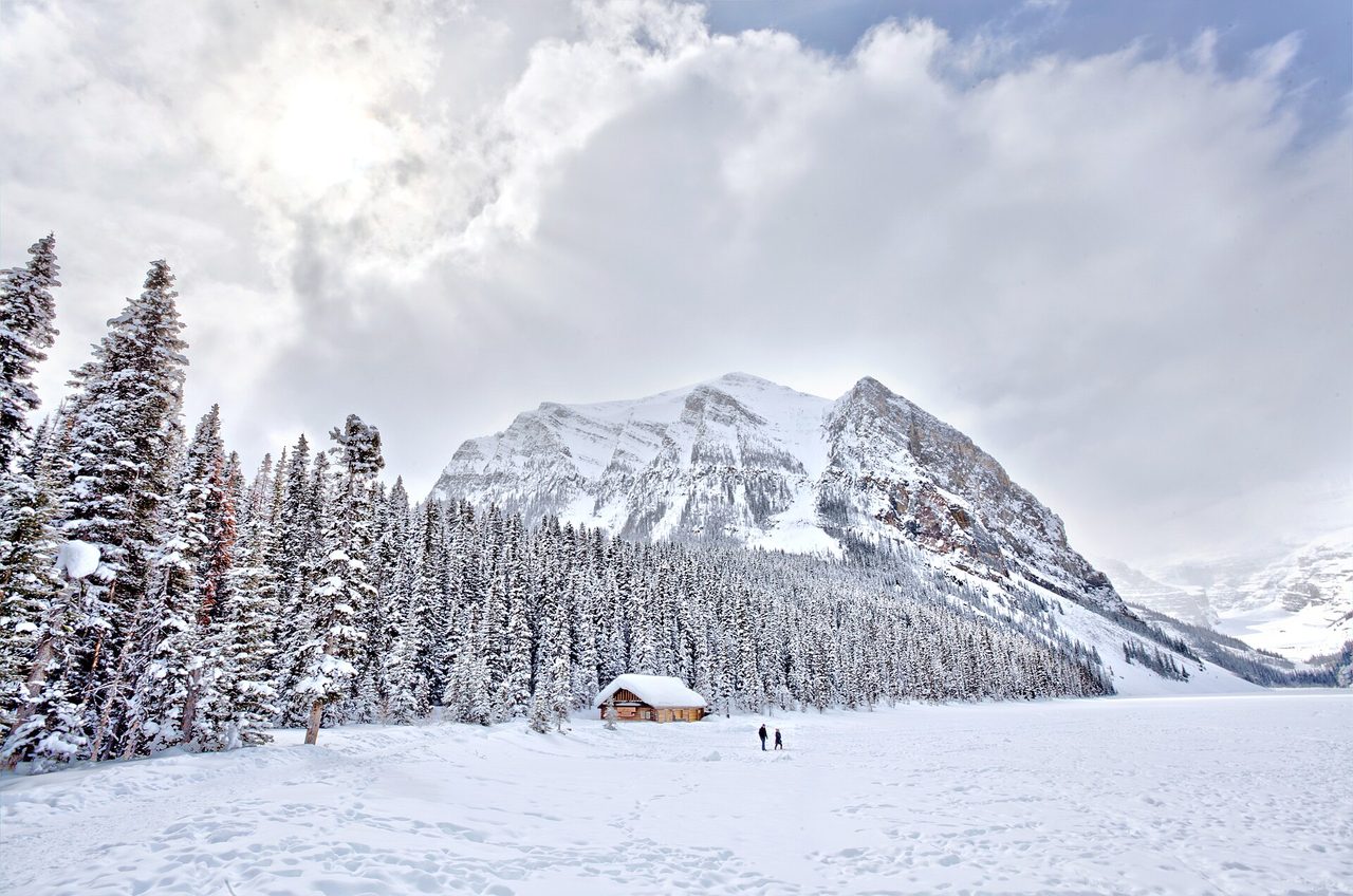 Frozen Lake Louise in winter with snow-covered peaks behind the Fairmont hotel