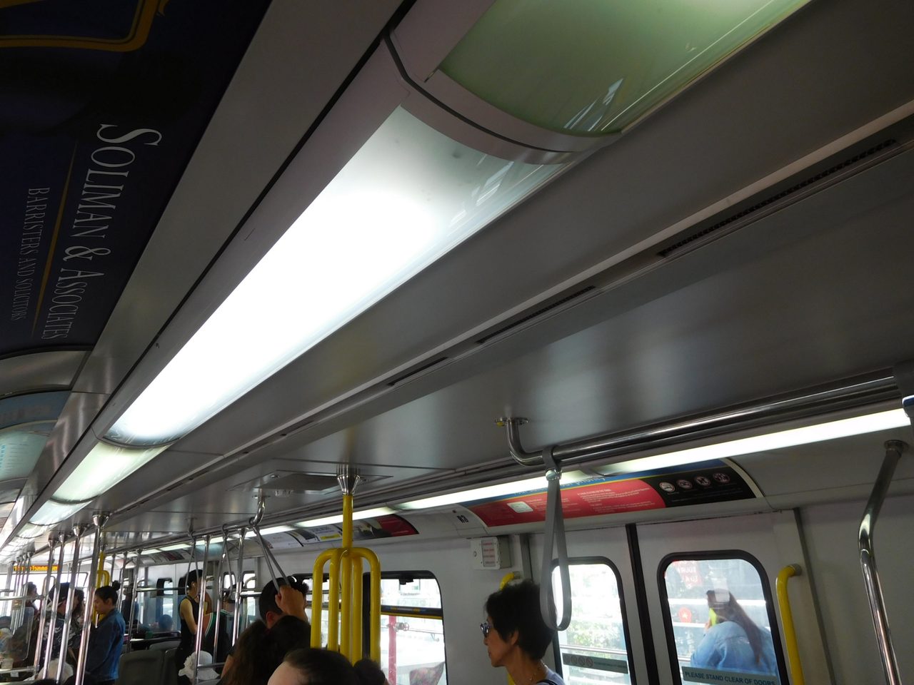 Interior of a Canada Line SkyTrain car in Vancouver, with yellow grab poles