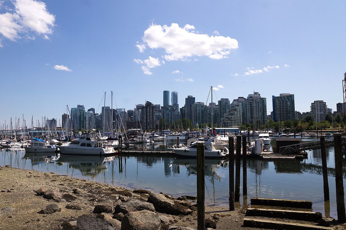 Vancouver's downtown skyline and busy harbour on a clear day, with the North Shore mountains behind