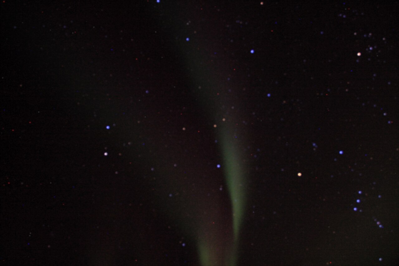 Green aurora borealis dancing over a snowy landscape near Yellowknife, Canada