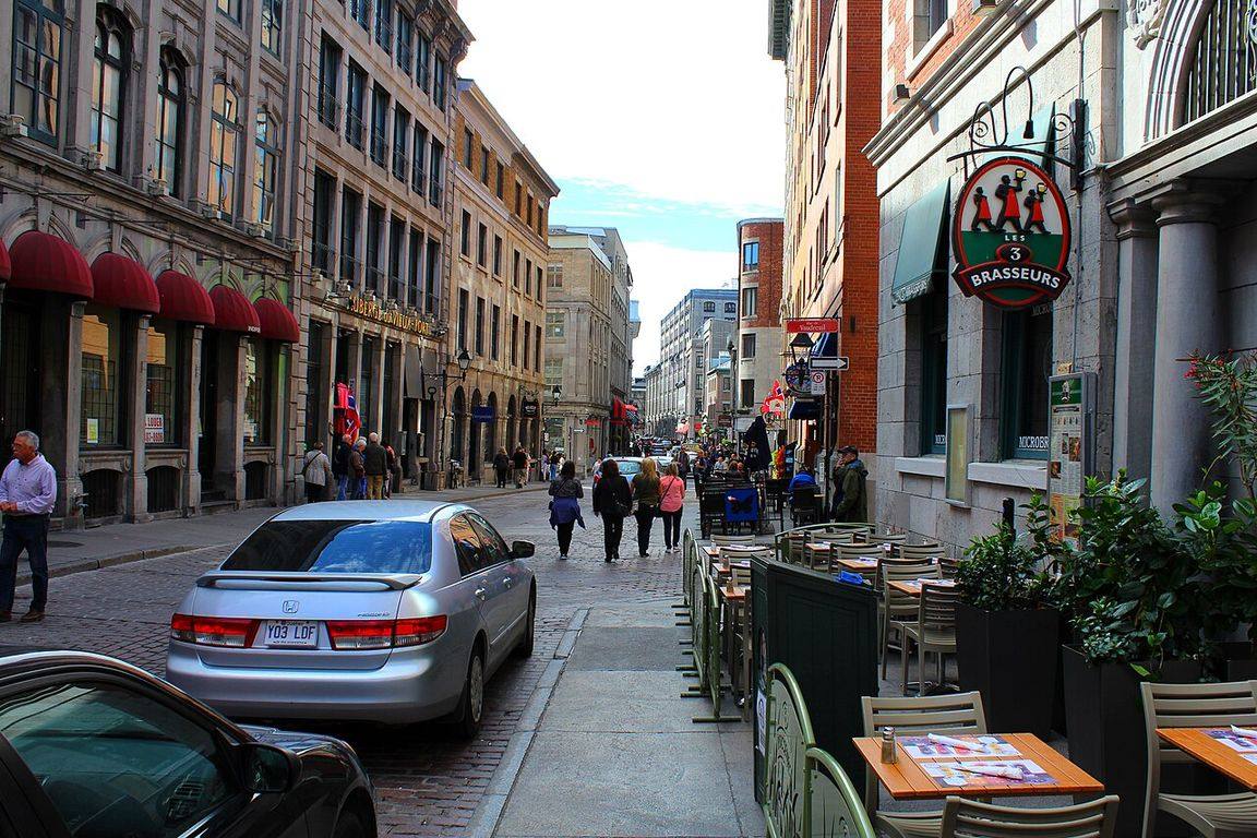 Historic stone buildings and cobblestone street in Old Montréal's Rue Saint-Paul on a sunny afternoon