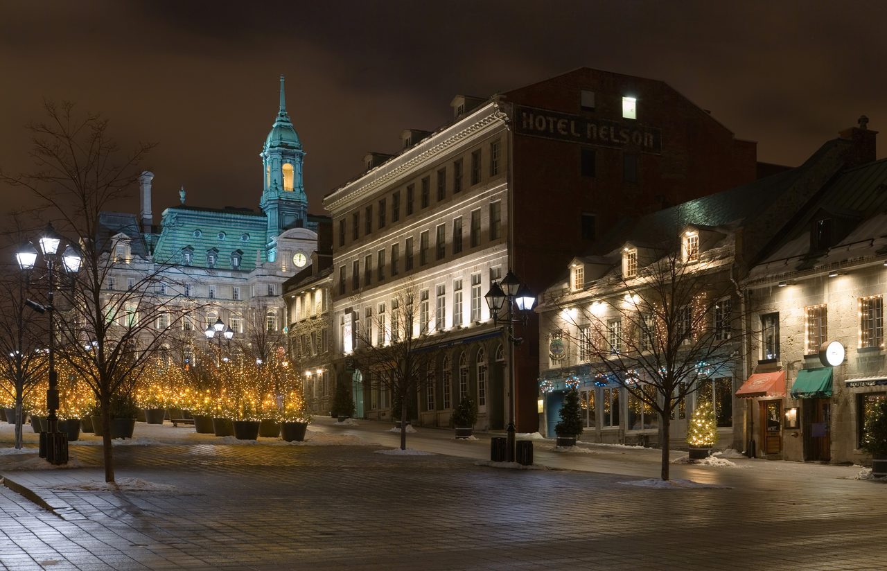 Snow-covered Place Jacques-Cartier in Old Montreal on a winter day, with historic stone buildings and bare trees