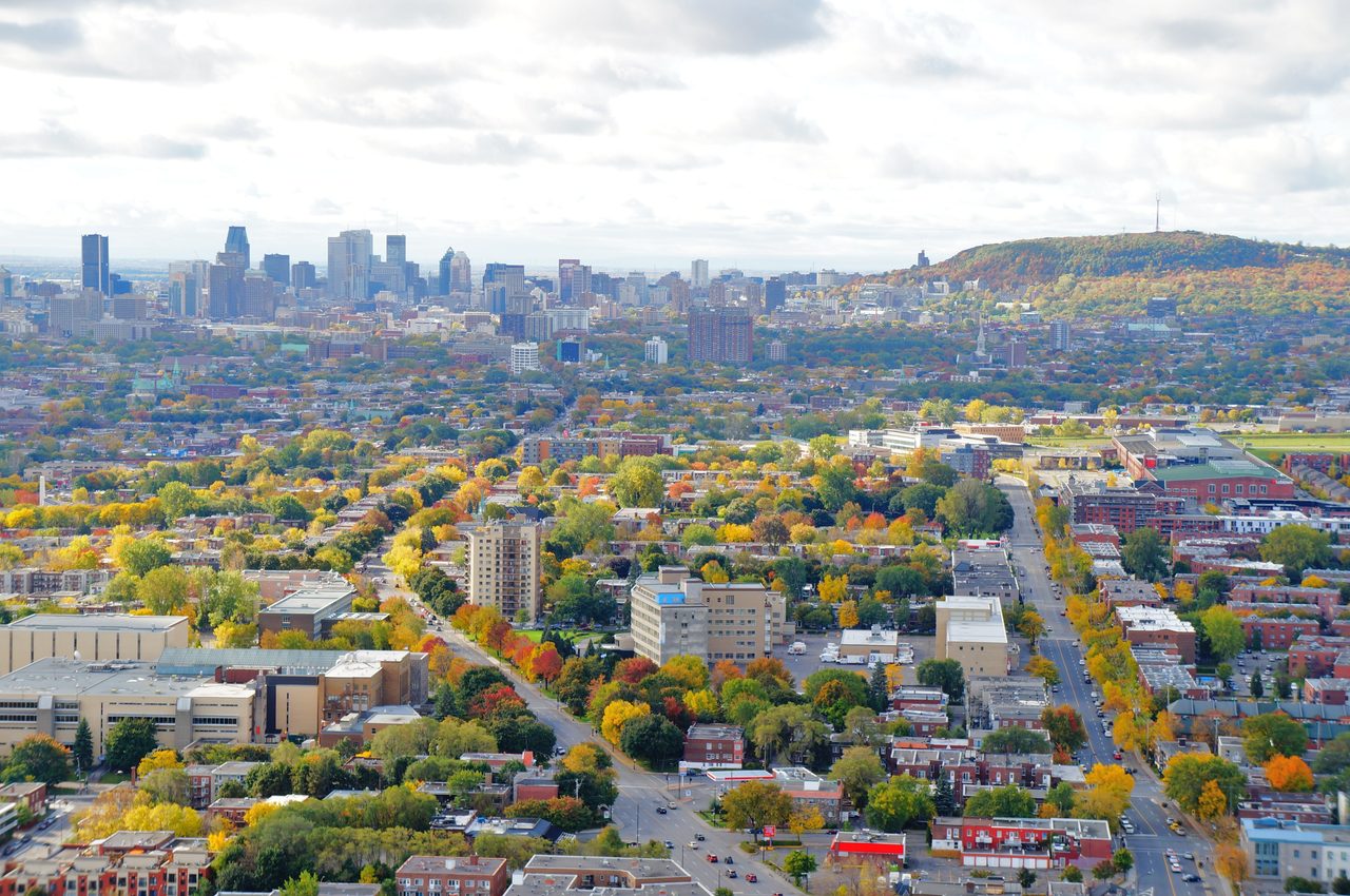 Montreal downtown skyline backed by Mount Royal, with trees turning yellow and orange in early fall