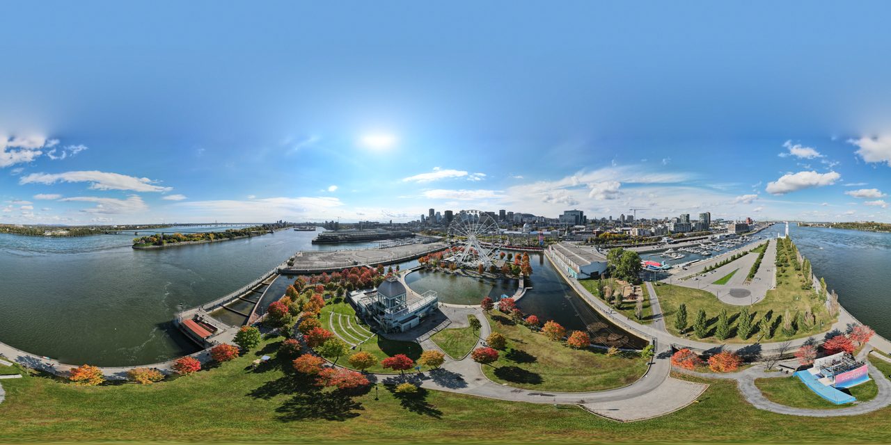 Panoramic view of Montreal's Old Port in autumn, with red fall trees, the Grande Roue Ferris wheel and the downtown skyline