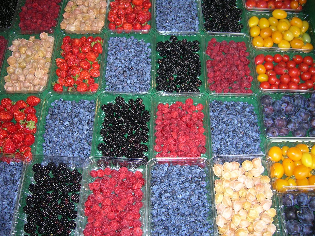 Trays of colorful Quebec berries and fruit — strawberries, blueberries, raspberries and blackberries — at Jean-Talon Market