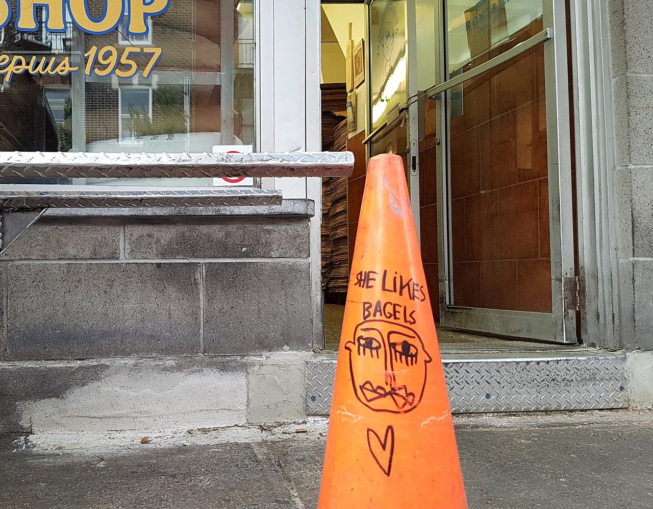 Entrance of the St-Viateur Bagel shop in Mile End, with stacks of paper bags of fresh bagels visible inside the doorway